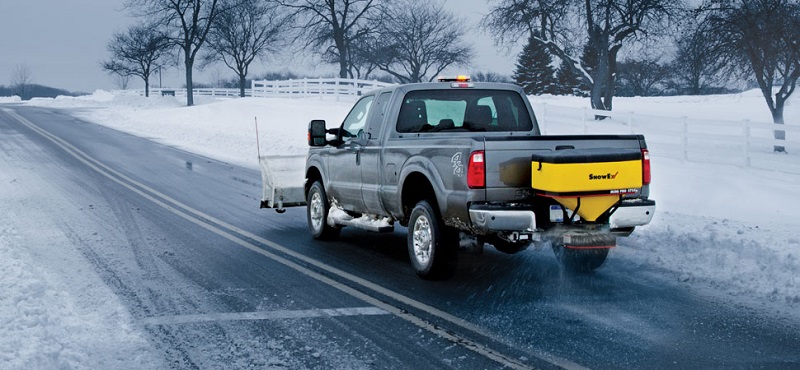 truck on icy road applying salt