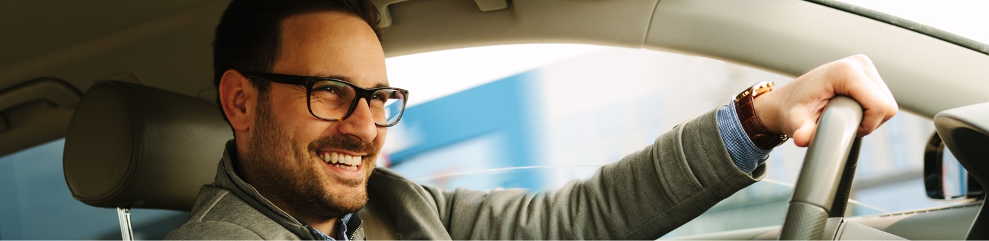 Smiling Man Driving Car Wearing Glasses