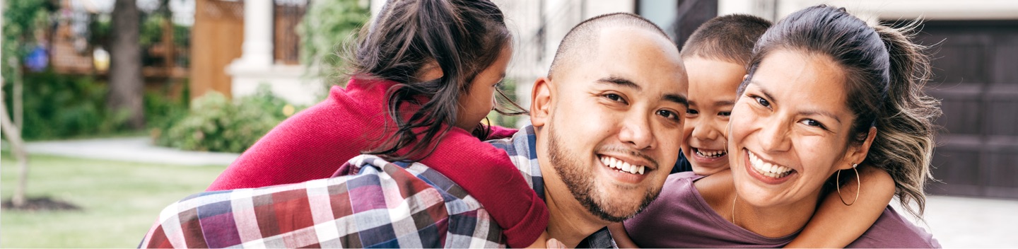 Young Family Smiling At Camera