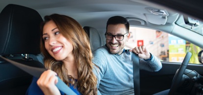 Woman And Man Smiling Putting On Seatbelts