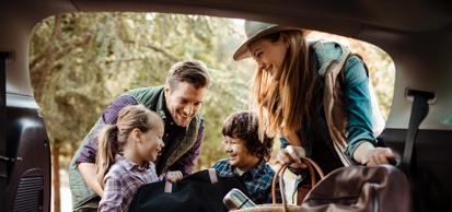 Young, Smiling Family Engaging With Luggage