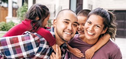 Young Family Smiling At Camera